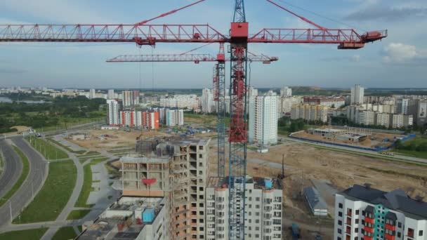 Fotografía aérea de la obra. Construcción de modernos edificios de varios pisos. Despegue vertical sobre el fondo de las grúas de construcción. — Vídeo de stock