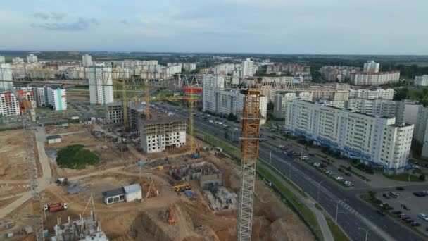 Vista aérea del nuevo desarrollo urbano. Se están construyendo nuevas casas. Vuelo en círculo alrededor de la manzana en construcción. Las grúas son visibles. Volando de lado. — Vídeos de Stock