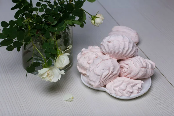 お皿の上に自家製のマシュマロ さまざまな形 古典的でハート型のマシュマロ 近くにはバラの花束があります — ストック写真