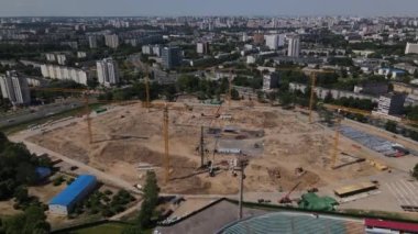 Şehir parkındaki futbol stadyumu. Yakınlarda yeni bir arena inşa ediliyor. Yeşil bir alan ve stantlar görülebilir, farklı renklerde boyanmış. Şehir manzarası. Hava fotoğrafçılığı..