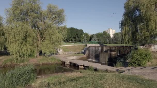 Fountains and cascades on the city river. There is a lot of greenery around. Flight over the city reservoir. Aerial photography. — Stock Video