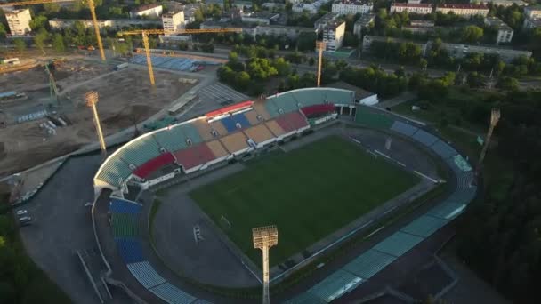 市内公園内のサッカースタジアム。緑のフィールドとスタンドが表示され、異なる色で塗装されます。物体から離れる。空中写真. — ストック動画