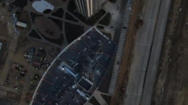 Çok katlı yeni binalar. Yeni bina bloğu. İnşaat alanında çalışmalar devam ediyor. Kamera devre dışı. Batan güneş evlerin pencerelerine yansıyor. Hava fotoğrafçılığı.