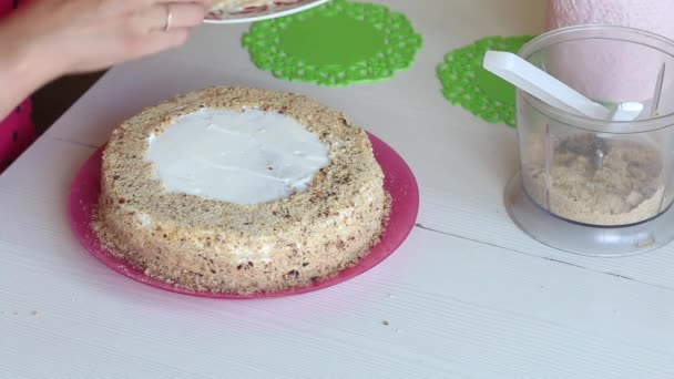 Bir kadın pastayı badem yapraklarıyla süslüyor. Kremayla kaplanmış kek. Yukarıdan yakın çekim. — Stok video