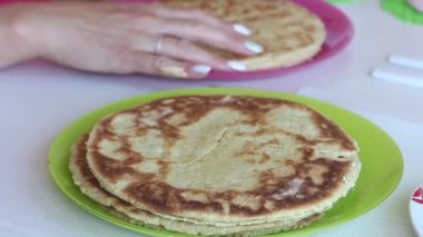 Bir kadın pasta tabakalarına krema sürer. Yığınlar üst üste yığılır. Pasta yapmak için gerekli malzemeler..