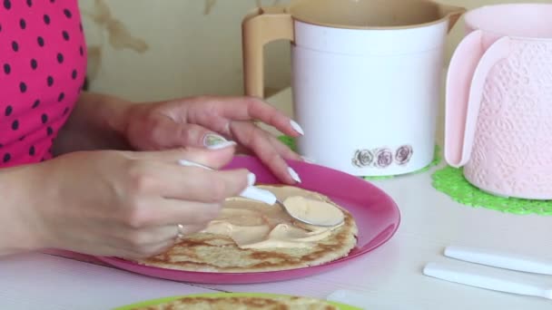 Bir kadın pasta tabakalarına krema sürer. Ellerinin ve pastasının yakın çekimleri.. — Stok video