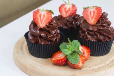 Çilekli ve naneli çikolatalı kekler. Böğürtlenler ikiye bölündü. Yakın çekim..