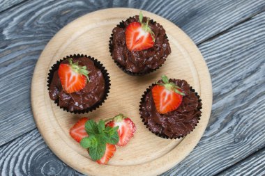 Çilekli ve naneli çikolatalı kekler. Böğürtlenler ikiye bölündü. Yakın çekim..