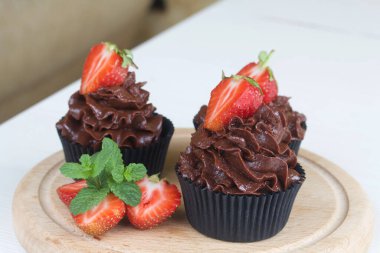 Çilekli ve naneli çikolatalı kekler. Böğürtlenler ikiye bölündü. Yakın çekim..