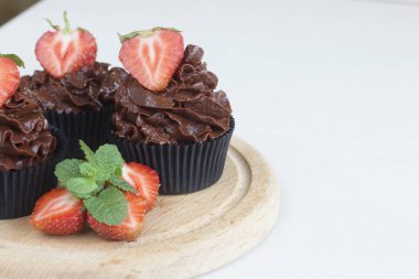 Çilekli ve naneli çikolatalı kekler. Böğürtlenler ikiye bölündü. Yakın çekim..