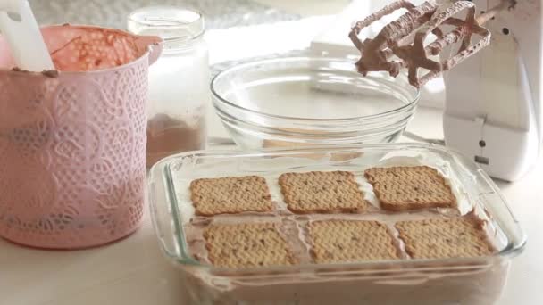 Schlagsahne und Kekse in einer Glaspfanne. Hausgemachtes Eis zubereiten. In der Nähe Werkzeuge und Zutaten. Nahaufnahme. — Stockvideo