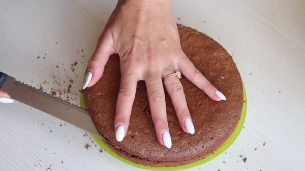 Kobieta kroi ciastko z ciastem. Na ciasto czekoladowe z orzeszkami ziemnymi i truskawkami. Strzał z bliska — Wideo stockowe