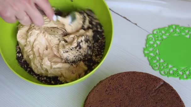 Una mujer mezcla cacahuetes y chocolate en un recipiente. Hace crema de pastel de chocolate con cacahuete y fresa. Filmado desde arriba. — Vídeos de Stock