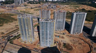 Modern şehir gelişimi. İnşaat alanında çok katlı binalar inşa ediliyor. Yeni bir şehir bloğu inşaatı. Hava fotoğrafçılığı.