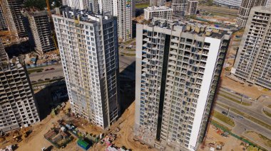 Modern şehir gelişimi. İnşaat alanında çok katlı binalar inşa ediliyor. Yeni bir şehir bloğu inşaatı. Hava fotoğrafçılığı.