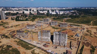 Modern şehir gelişimi. İnşaat alanında çok katlı binalar inşa ediliyor. Yeni bir şehir bloğu inşaatı. Hava fotoğrafçılığı.