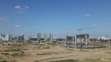 Modern bir şehir bloğunun inşaatı. İnşaat alanında binaların beton çerçeveleri görülebiliyor. İnşaat vinçleri çalışıyor. Hava fotoğrafçılığı.