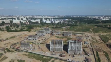 Modern bir şehir bloğunun inşaatı. İnşaat alanında binaların beton çerçeveleri görülebiliyor. İnşaat vinçleri çalışıyor. Hava fotoğrafçılığı.