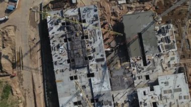 İnşaat alanı. Binanın beton iskeleti inşa ediliyor. İnşaat vinçleri çalışıyor. Şehir binaları görülebilir durumda. Hava fotoğrafçılığı.