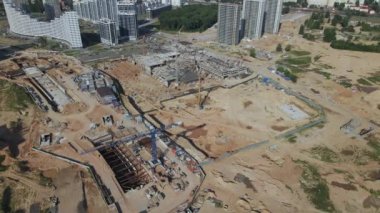 İnşaat alanı. Binanın beton iskeleti inşa ediliyor. İnşaat vinçleri çalışıyor. Şehir binaları görülebilir durumda. Hava fotoğrafçılığı.