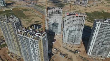 İnşaat alanı. Binanın beton iskeleti inşa ediliyor. İnşaat vinçleri çalışıyor. Şehir binaları görülebilir durumda. Hava fotoğrafçılığı.