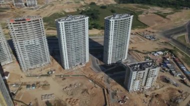 İnşaat alanı. Binanın beton iskeleti inşa ediliyor. İnşaat vinçleri çalışıyor. Şehir binaları görülebilir durumda. Hava fotoğrafçılığı.
