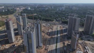 İnşaat alanı. Binanın beton iskeleti inşa ediliyor. İnşaat vinçleri çalışıyor. Şehir binaları görülebilir durumda. Hava fotoğrafçılığı.