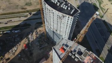 İnşaat alanı. Binanın beton iskeleti inşa ediliyor. İnşaat vinçleri çalışıyor. Şehir binaları görülebilir durumda. Hava fotoğrafçılığı.