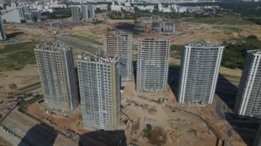 İnşaat alanı. Binanın beton iskeleti inşa ediliyor. İnşaat vinçleri çalışıyor. Şehir binaları görülebilir durumda. Hava fotoğrafçılığı.