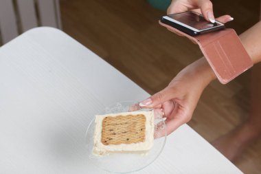 Bir kadın ev yapımı dondurma fotoğrafı çekiyor. Kurabiye ve krema. Yakın çekim..