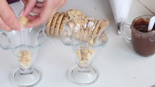 Une femme fait des miettes de biscuits à partir de biscuits. Pour biscuit, chocolat et dessert à la crème. Gros plan. — Video