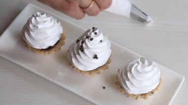 Bir kadın kek sepetine çikolata damlası döküyor. Yakın çekim..
