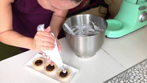 Una donna mette la panna su un brownie al cioccolato. Un cesto sta preparando una torta. Primo piano.. — Video Stock