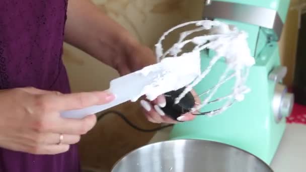 The woman removes the cream from the whisk from the planetary mixer. Prepares cream for dessert. Close-up shot. — Stock Video