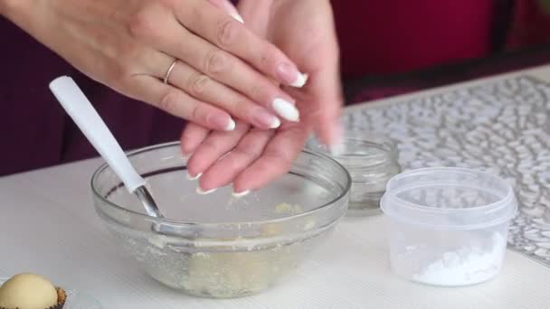 Una mujer hace dulces con mazapán. Rollos de bolas de harina de almendras y azúcar en polvo con las manos. Lugares en tartaletas. Primer plano de disparo. — Vídeos de Stock