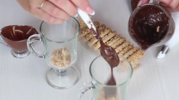 La donna aggiunge il cioccolato al dessert. Dessert di cottura da briciole di biscotto, cioccolato e crema. Primo piano.. — Video Stock