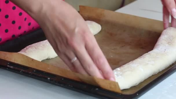 Eine Frau legt Rohlinge für Brot auf ein Backblech. Nahaufnahme. — Stockvideo