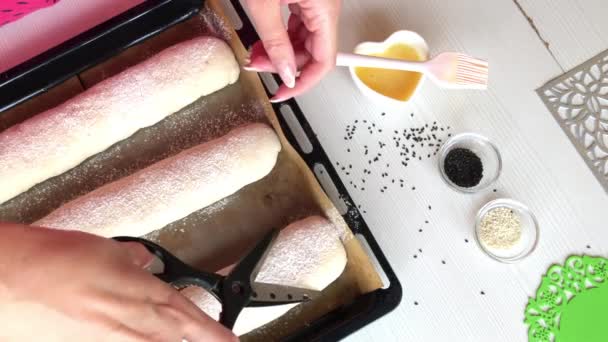 女性はライ麦パンを用意します。はさみでワークを切り、パンをスパイク状に成形します。上から撮影. — ストック動画