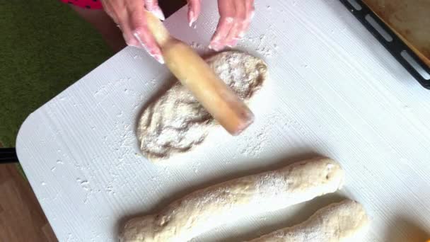 Una mujer prepara pan de centeno. Ella saca la masa y la moldea en un espacio en blanco. Filmado desde arriba — Vídeos de Stock