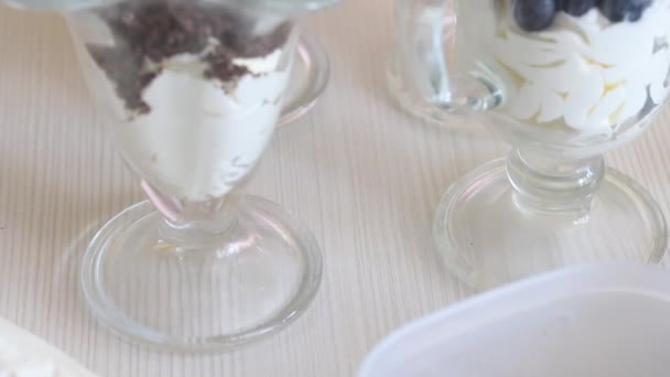 Десерт со взбитыми сливками, черникой и шоколадом. Крупный план. — стоковое видео