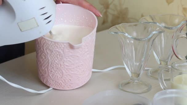 한 여자가 크 리임 과 응축 우유를 그릇에 넣고 있다. 디저트로 크림을 미리 비교함. — 비디오