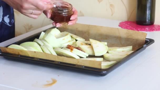 一个女人在切碎的西葫芦里加了大蒜和橄榄油。在烘烤单上，切碎的拉链，用于烘烤. — 图库视频影像