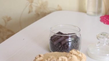 Carrot cake decorated with cream. Next to it is a jar of chocolate drops for decoration. Close-up shot.