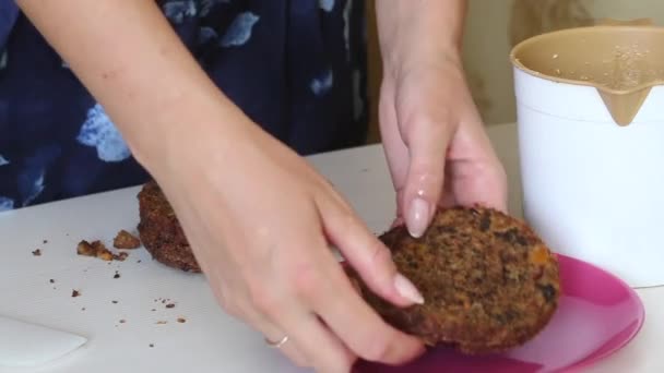 Möhrenkuchen kochen. Eine Frau streicht Sahne auf die Tortenschichten. Nahaufnahme. — Stockvideo