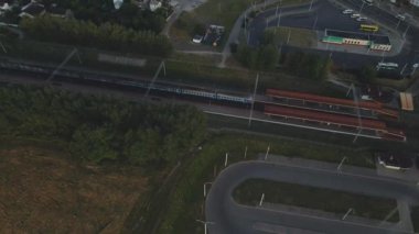 Şafakta şehir üzerinde uçacağız. Doğan güneşin ışınlarında, çok katlı binalar ve yeşil bir alan görülebilir. Hava fotoğrafçılığı.