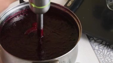 Bir kadın yaban mersini ve şekeri püre yapmak için blender kullanır. Evde yabanmersini reçeli yapıyorum. Yabanmersinlerinin korunması ve hazırlanması. Yakın çekim...