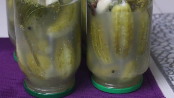 Potten met gepekelde komkommers. Ga met het deksel naar beneden. Pickling komkommers thuis. Plantaardige oogstbescherming. Close-up opname. — Stockvideo