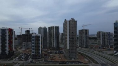 Yeni bir şehir bloğu için inşaat alanı. Tamamlanan evler bitirme aşamasında görülebilir. İnşaat çalışmaları devam ediyor. Gün batımında uçmak. Hava fotoğrafçılığı.