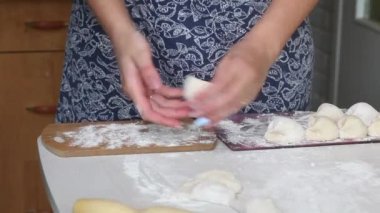 Kadın köfteleri kesim tahtasına koyuyor. Yakın çekim..