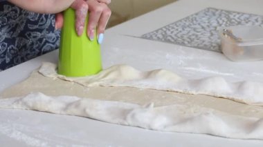 Bir kadın plastik bardakla hamur tatlısı yapıyor. Patatesli hamur tatlısı ve kıyma..